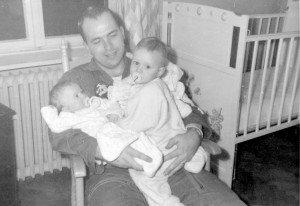 An adoptive father holds his two children.