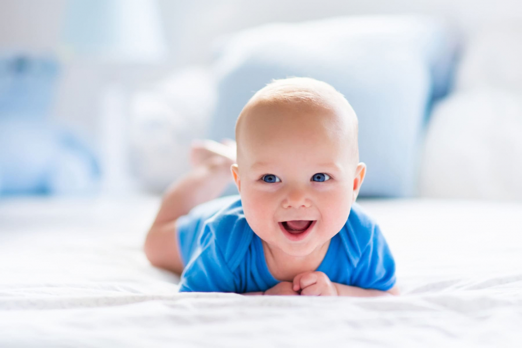 Baby boy in white sunny bedroom